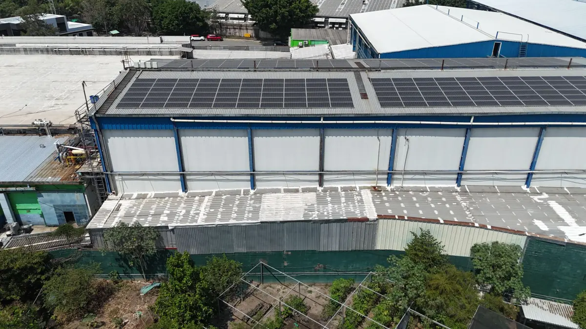 Vista aérea de paneles solares sobre el techo de una planta industrial