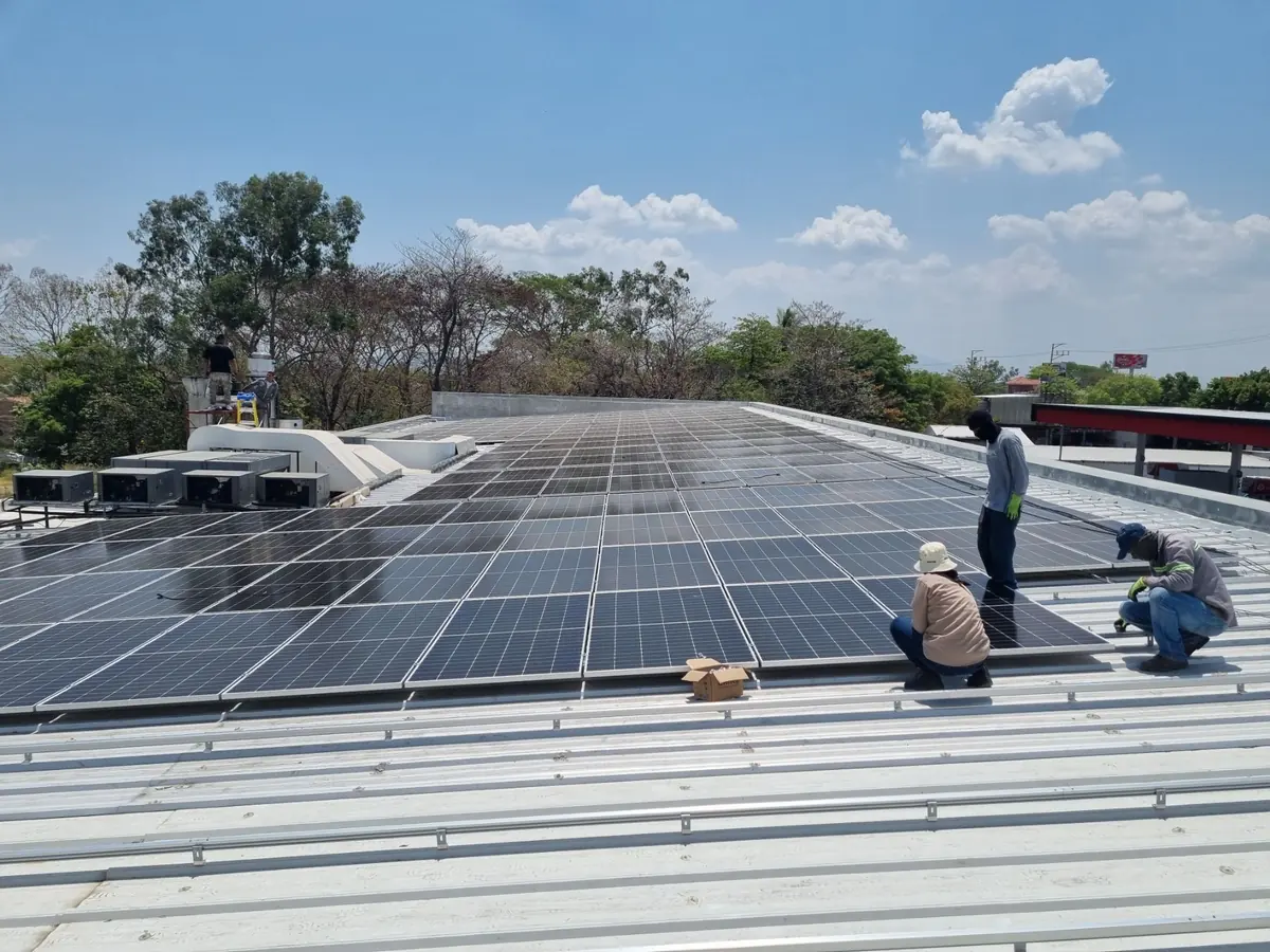 Técnicos montando paneles solares sobre un techo metálico