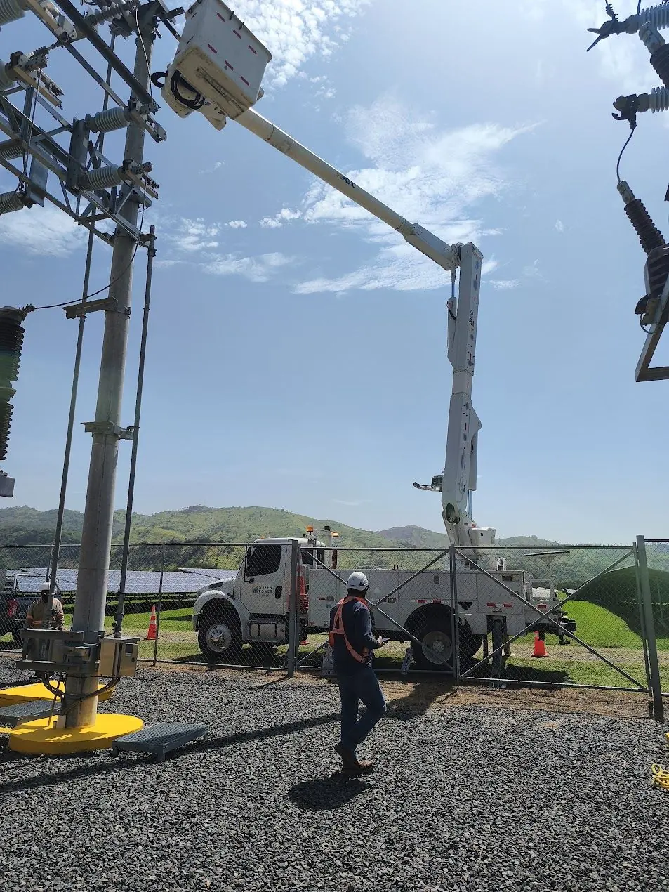 Camión canasta y técnico trabajando en una subestación eléctrica